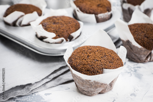 Chocolate muffins on the rustic background. Selective focus.