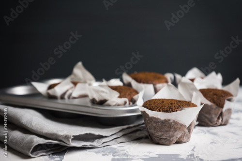 Chocolate muffins on the rustic background. Selective focus.