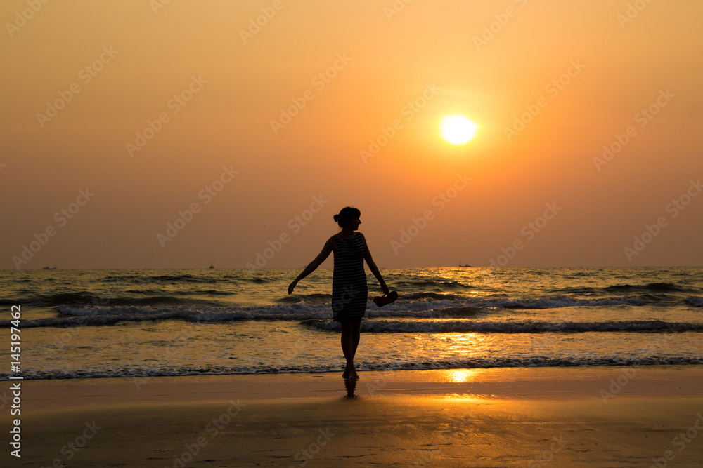 Silhouette of a beautiful young girl on sunset in India, Goa, Arambol beach
