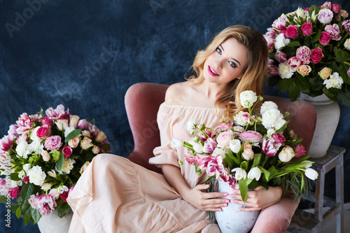 Portrait of a young blonde woman in flowers. Woman's face with make-up and hairstyle