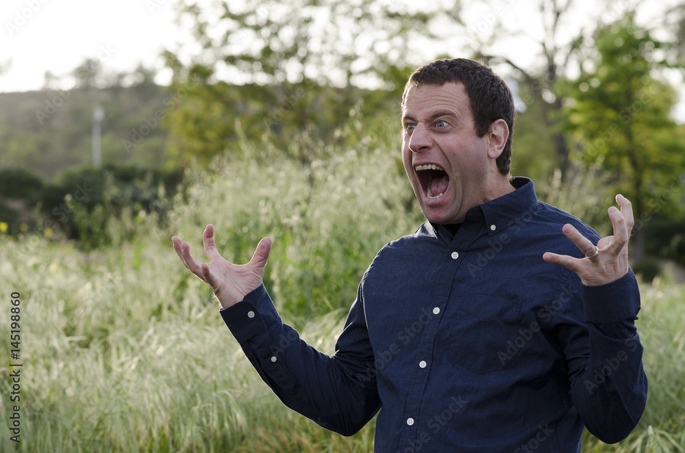 Man screaming in anger with hands out and mouth wide open. Man screaming in anger with hands out and mouth wide open.