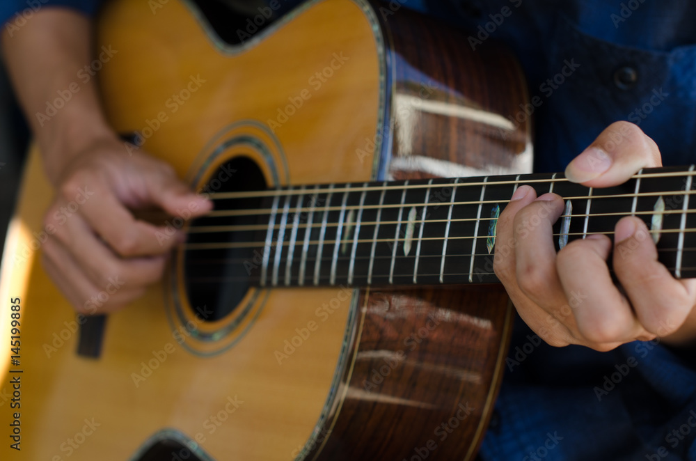 Fototapeta premium .A young boy sitting acoustic guitar happily.