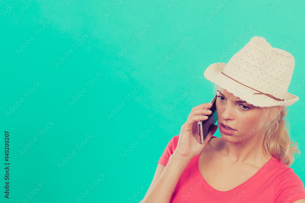 Tourist woman with sun hat talking on phone