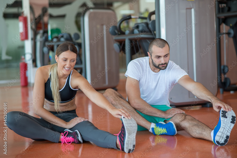 Young people involved in sports. Woman stretching with personal trainer Young people involved in sports. Woman stretching with personal trainer