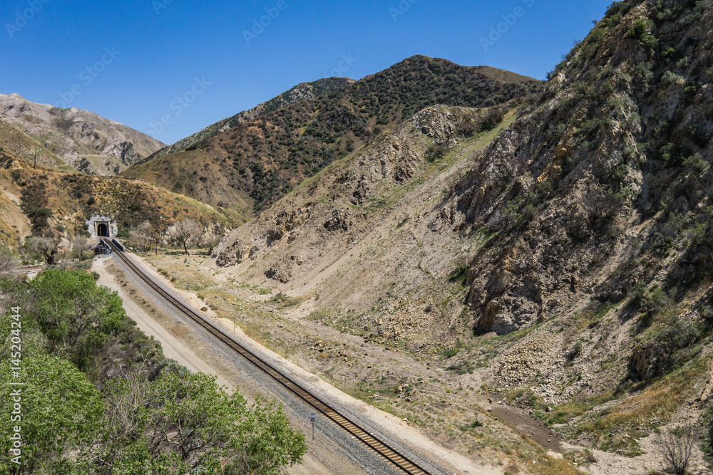 Railroad train track leads to tunnel in the San Gabriel mountains of Los Angeles County in California.