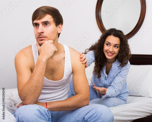 Smiling girl trying to comfort upset husband