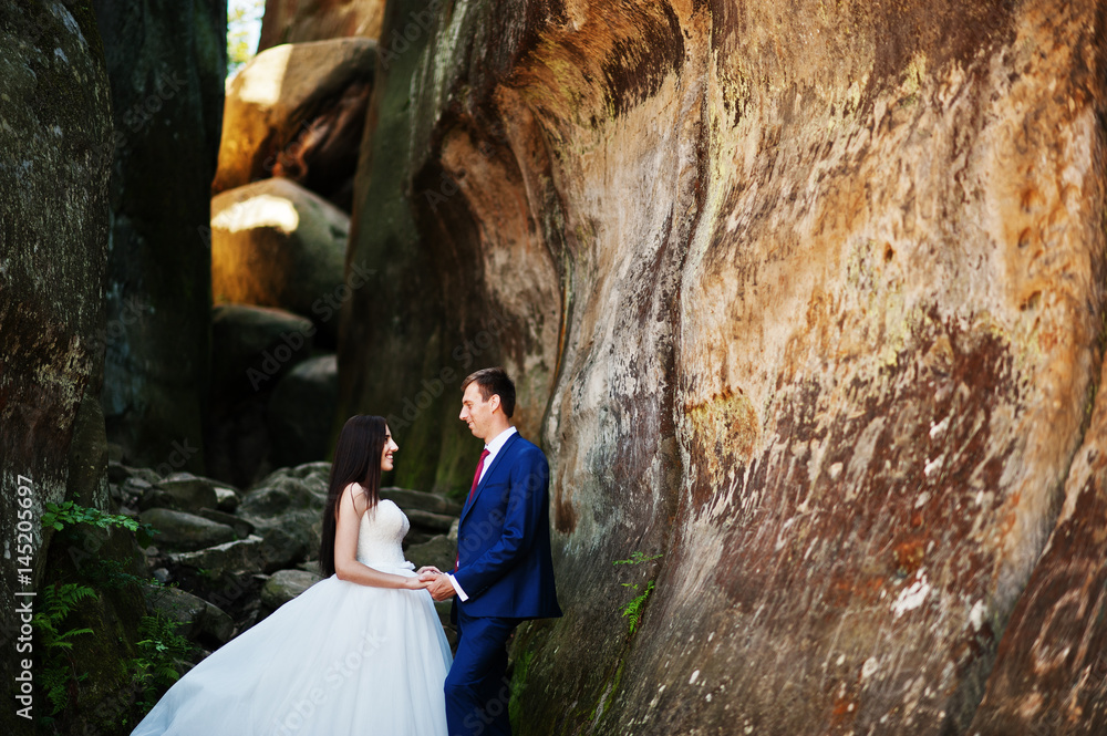 Lovely wedding couple at amazing landscapes with rock Dovbush, Carpathian mountains at Ukraine.