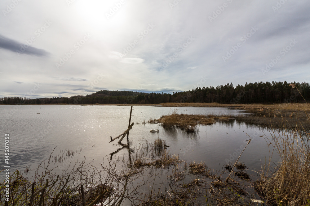 Sun behind clouds over lake, Gjennestadvannet, Stokke, Vestfold in Norway Sun behind clouds over lake, Gjennestadvannet, Stokke, Vestfold in Norway