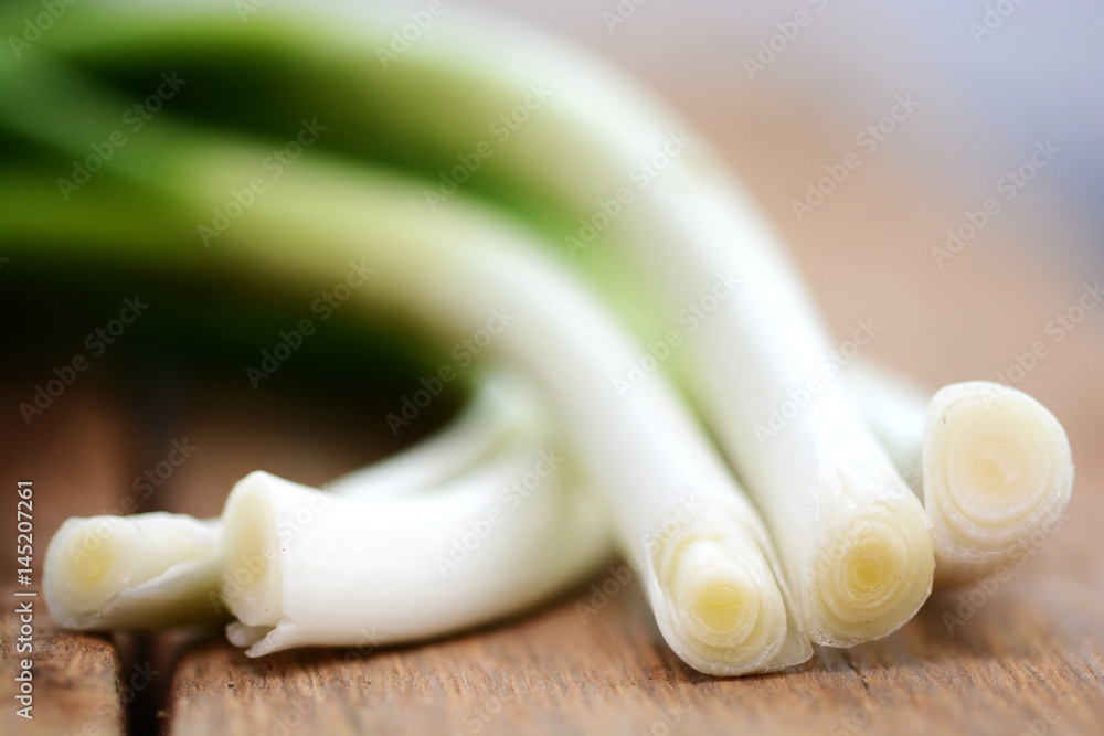 Bunch of Green onion on wooden cutting board, prepared for fresh salad Bunch of Green onion on wooden cutting board, prepared for fresh salad