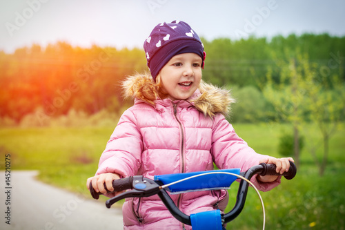 Happy little girl on a bicycle