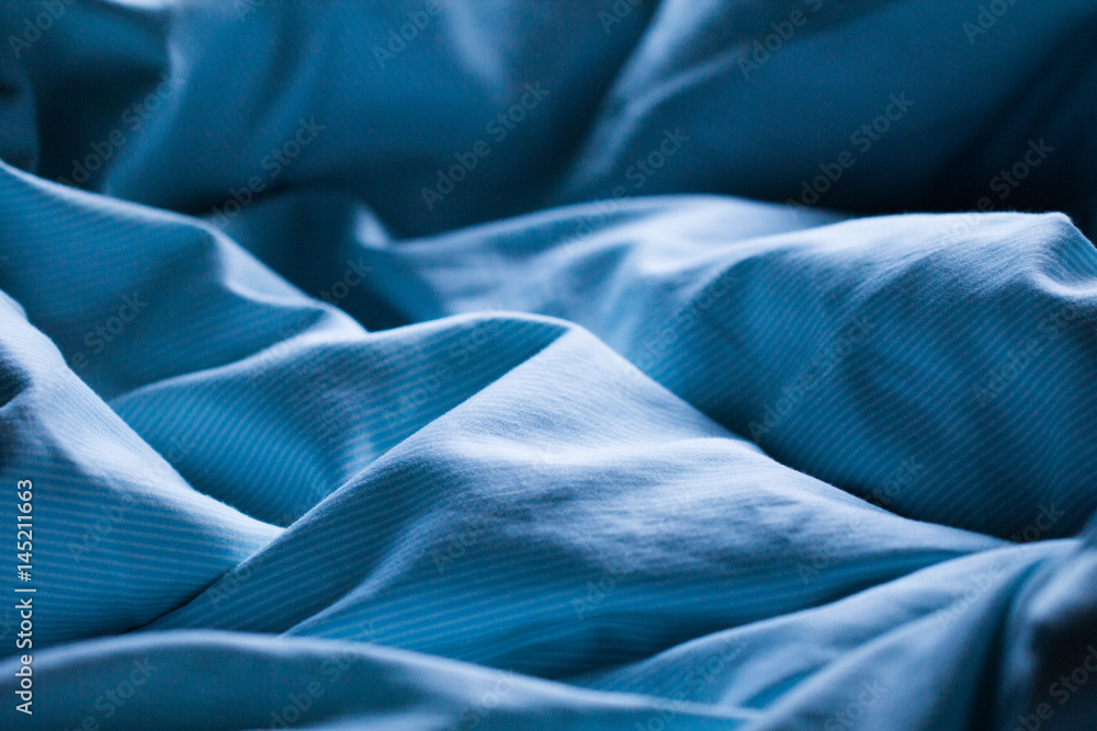 Gently sleeping blue bed sheet in soft morning or evening romantic sunlight as beautiful textile sleep relaxation decorative background - obrazy, fototapety, plakaty 