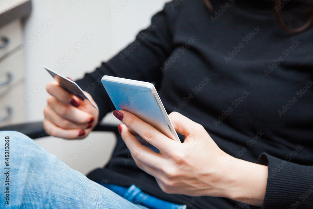 female hand holding plastic credit card and using smartphone female hand holding plastic credit card and using smartphone