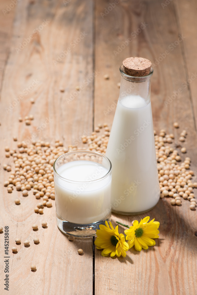 Soy milk or soya milk and soy beans in spoon on wooden table. Soy milk or soya milk and soy beans in spoon on wooden table.