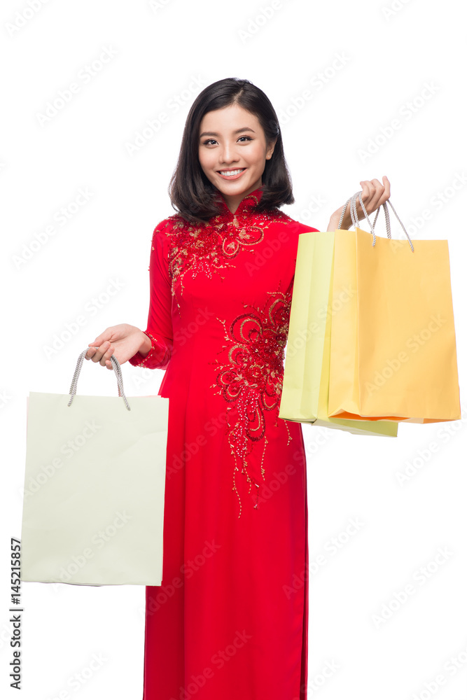 Charming Vietnamese Woman in Red Ao Dai Traditional Dress holding Shopping Bags. Charming Vietnamese Woman in Red Ao Dai Traditional Dress holding Shopping Bags.