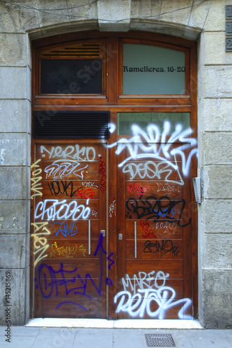 puerta de entrada a una casa pintada con grafitis y palabras, falta de civismo