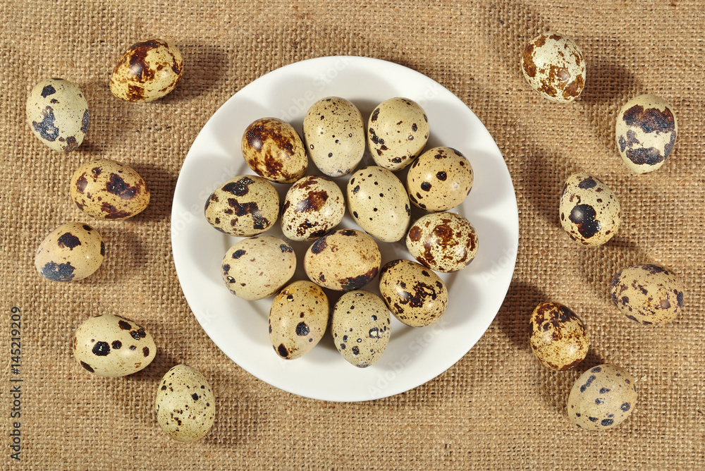 Quail eggs in a white bowl in a sacking Quail eggs in a white bowl in a sacking