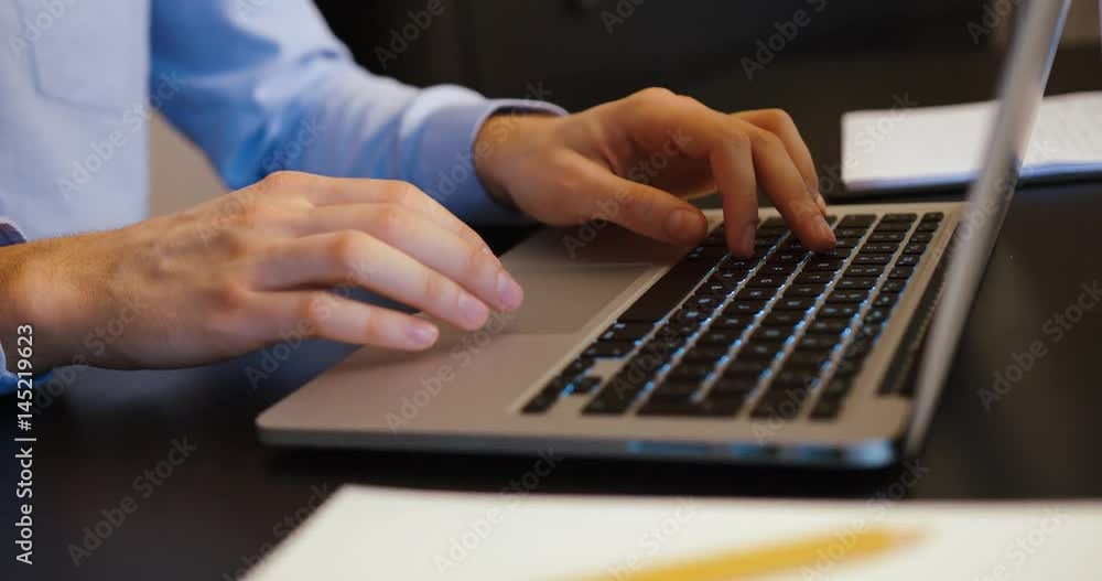 Business man typing on his laptop. Young man is working in office at computer. Close up shot. Business man typing on his laptop. Young man is working in office at computer. Close up shot.