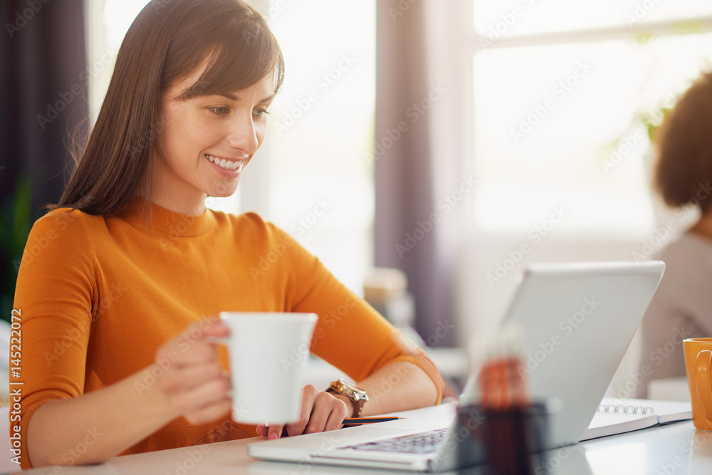 Young beautiful woman working in modern office sitting at the table with laptop Young beautiful woman working in modern office sitting at the table with laptop