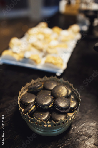 Black macaroons in silver bowl