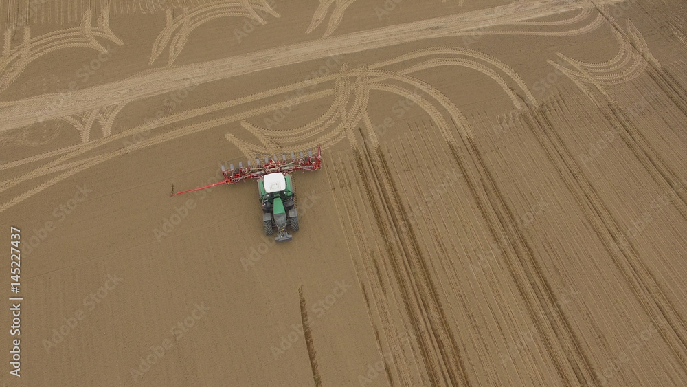 tractor - aerial view of a tractor at work - cultivating a field in spring - agricultural machinery