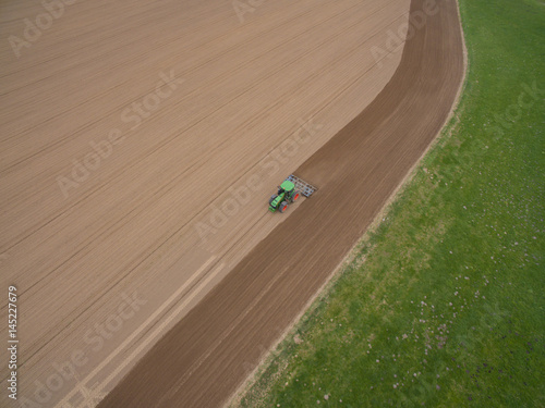 tractor - aerial view of a tractor at work - cultivating a field in spring - agricultural machinery