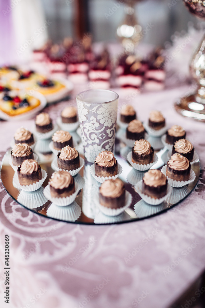The cupcakes standing on the buffet table The cupcakes standing on the buffet table