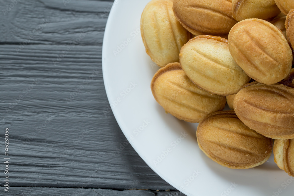 Obraz premium Pile of cookies with condenced milk on white plate