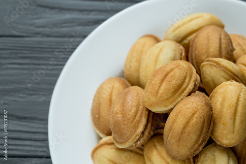 Pile of cookies with condenced boiled milk on white plate photo