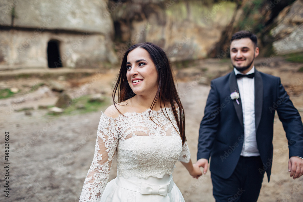 The charming brides walking near stones