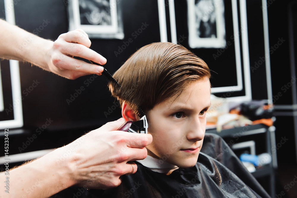 Fototapeta premium cute young boy getting a haircut