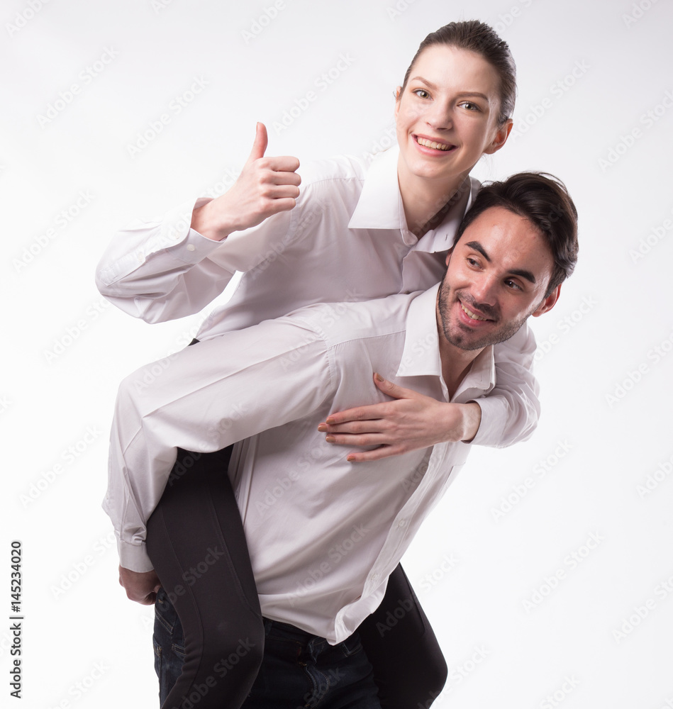 Young happy couple showing presentation pointing on placard over gray background Young happy couple showing presentation pointing on placard over gray background