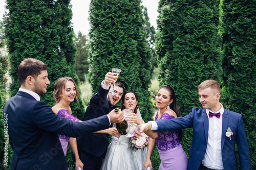 The brides,bridesmaids and groomsmen keeping glasses of champagne