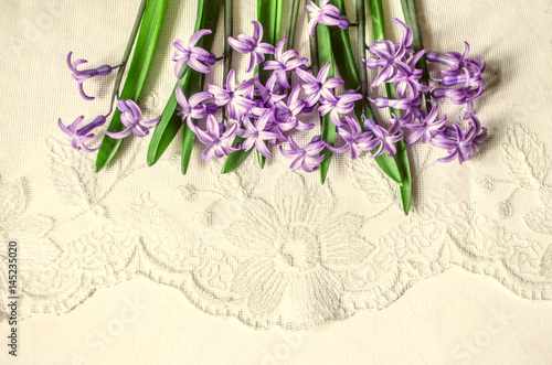  Postcard with lilac hyacinths lying top on the white lace background