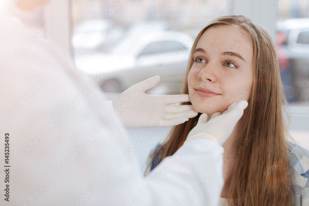 Skilled dermatologist examining patient skin in the clinic Skilled dermatologist examining patient skin in the clinic