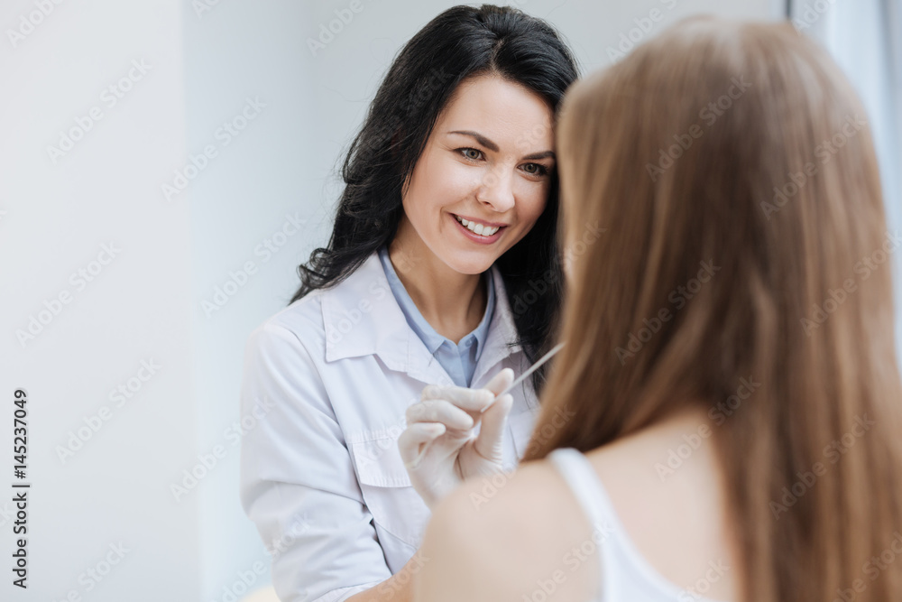 Pleasant young pediatrician examining teenager health in the hospital Pleasant young pediatrician examining teenager health in the hospital