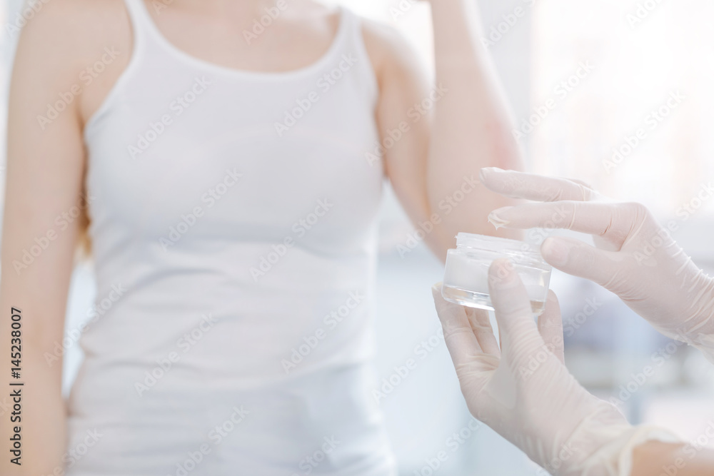 Skillful dermatologist applying medical cream on patient skin at work Skillful dermatologist applying medical cream on patient skin at work