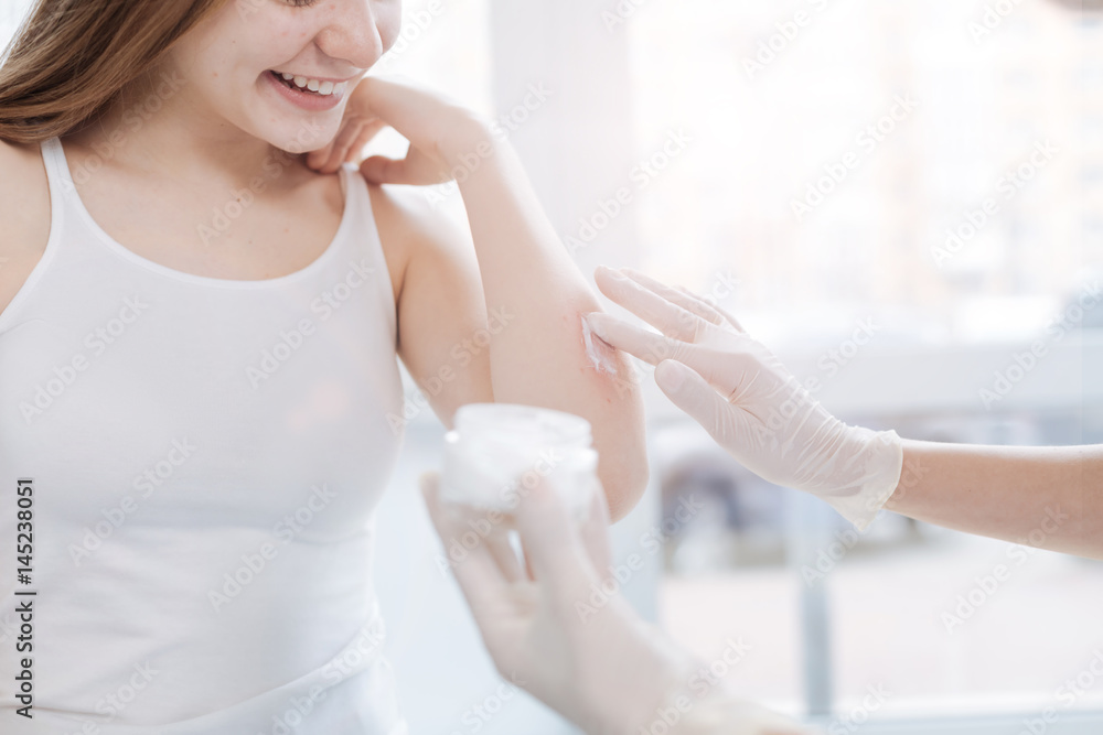 Professional practitioner testing new medical cream on patient skin at work Professional practitioner testing new medical cream on patient skin at work