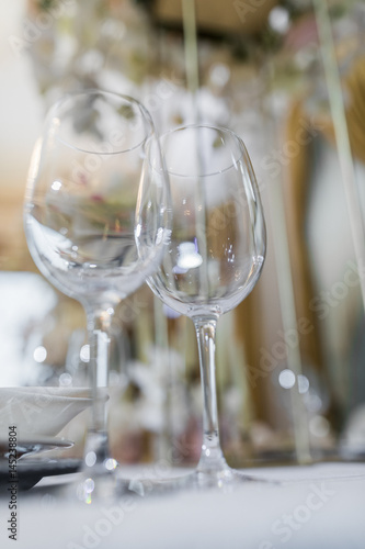 Crystal wineglasses stand side by side on the dinner table