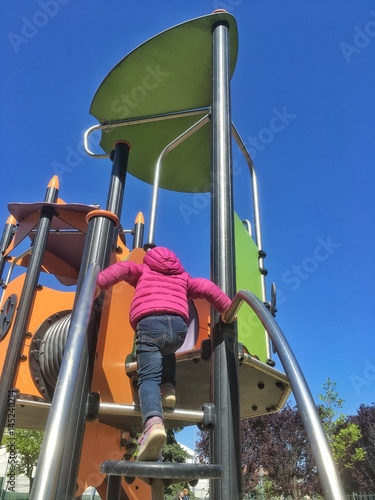 bambina impegnata sul percorso del parco giochi