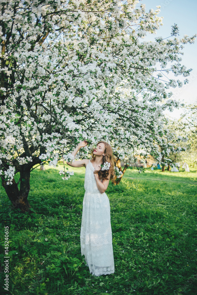 Obraz premium A girl in a blooming garden