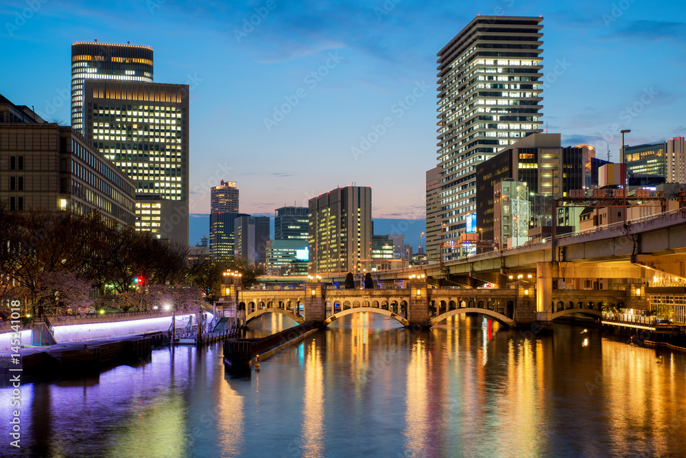 Fototapeta premium Budynek drapacza chmur w Osace w dzielnicy Nakanoshima w nocy w Osace w Japonii