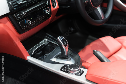 Red luxury car Interior with steering wheel, shift lever and air condition and radio button control in car