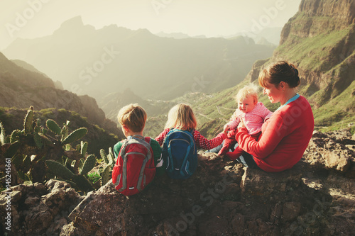 mother with three kids hiking in mountains
