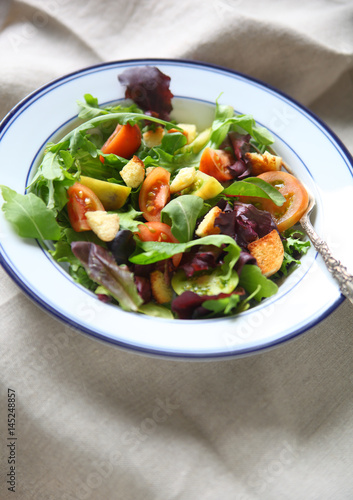 Salad with baby heirloom tomatoes and croutons on a beige napkin with copy space