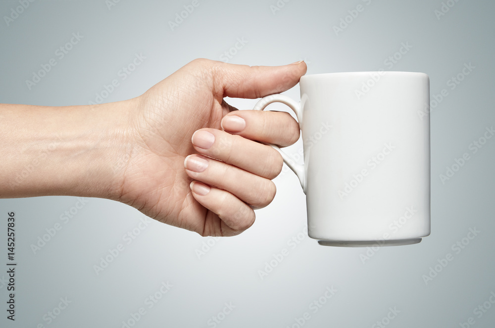 a woman hand holding a coffee mug Photos | Adobe Stock