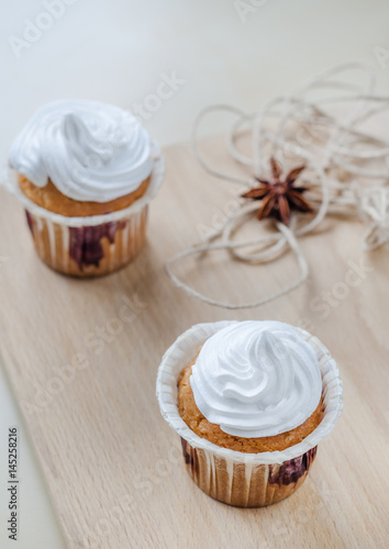 Cakes with cream on wooden board
