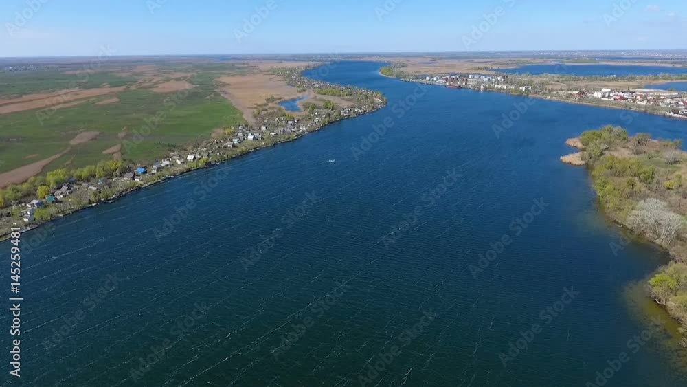 Amazing view on the beautiful blue waters of the Dnipro with its two river banks and a lot of wild greenary on them, splendid riverscape, in a sunny daytime, being taken from an aerial perspective Amazing view on the beautiful blue waters of the Dnipro with its two river banks and a lot of wild greenary on them, splendid riverscape, in a sunny daytime, being taken from an aerial perspective