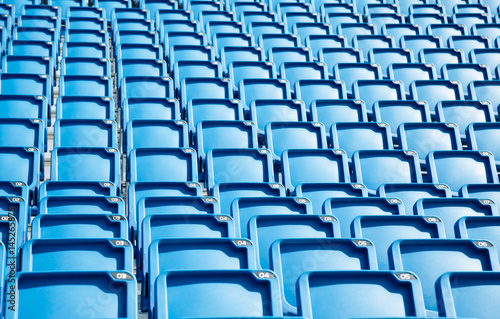 Folded blue plastic chairs on a tribune