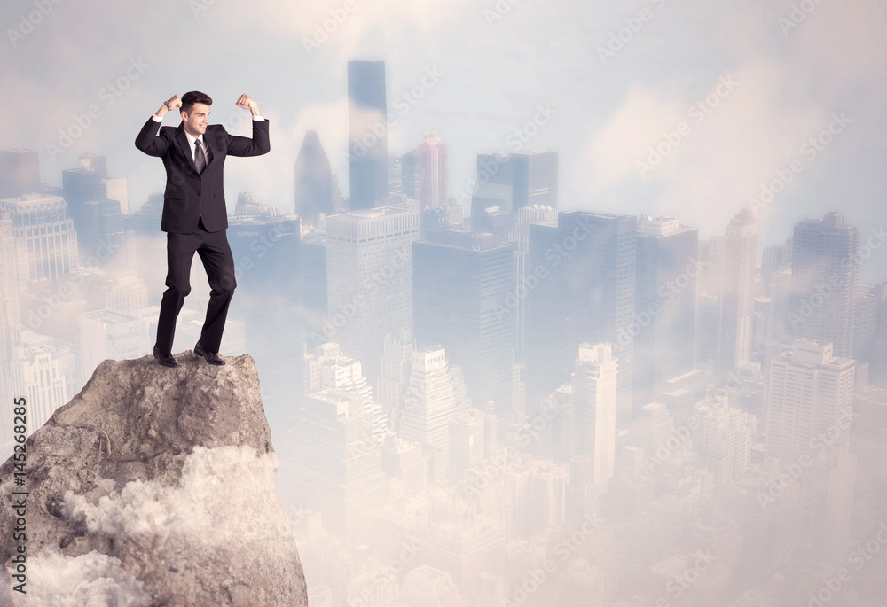 Winner urban businessman on top of stone Winner urban businessman on top of stone