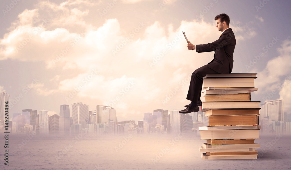 businessman with laptop sitting on books businessman with laptop sitting on books